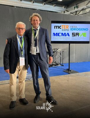 Due persone in piedi in posa durante una conferenza scientifica